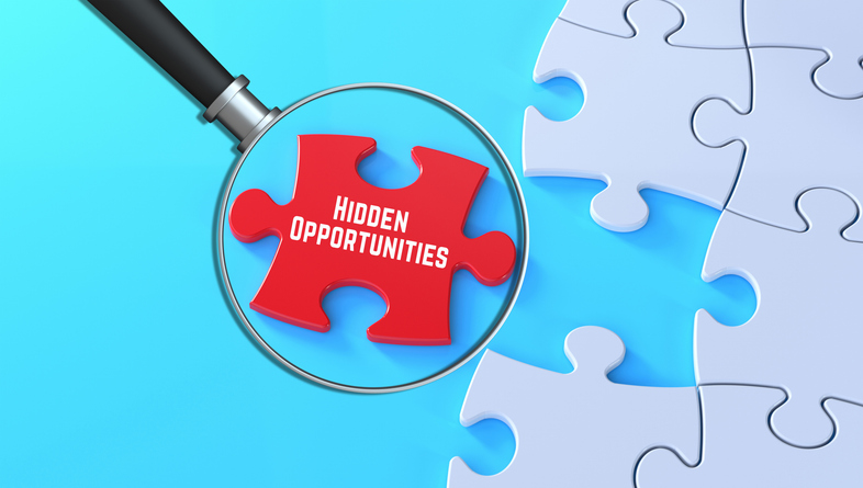 hidden-opportunities-message-magnified-on-red-puzzle-background-in-3d-text-banner-style